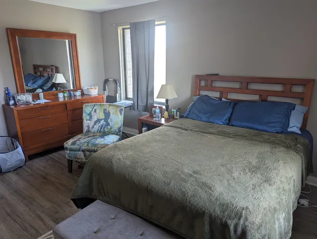 a bed sitting in a bedroom next to a window with a mirror