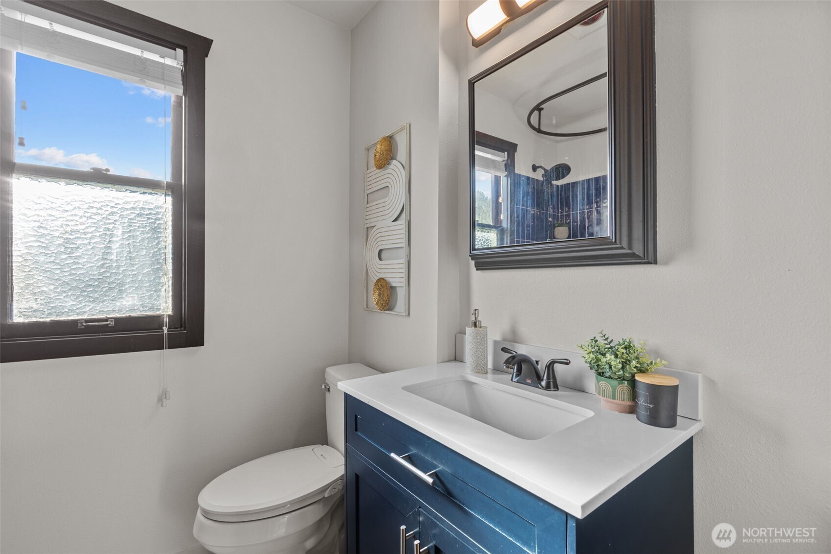 4219 South Mead Street Seattle, WA 98118 - Photo 17 of 40 a bathroom with a toilet sink vanity and mirror