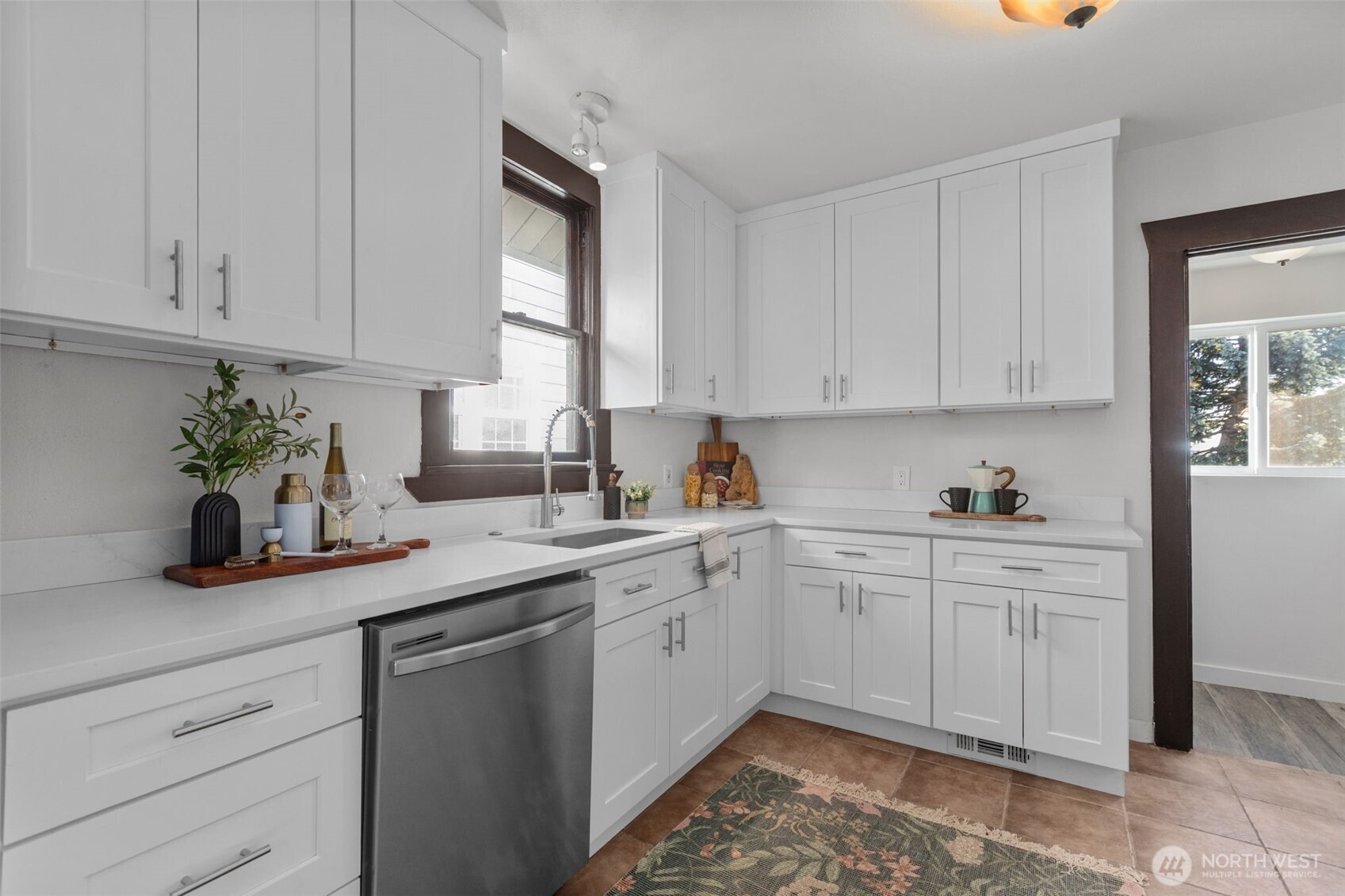 4219 South Mead Street Seattle, WA 98118 - Photo 9 of 40 a kitchen with white cabinets and a sink
