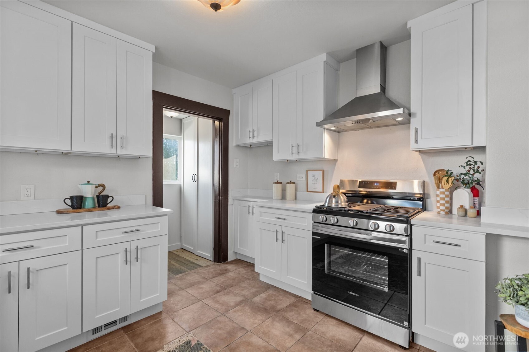 4219 South Mead Street Seattle, WA 98118 - Photo 10 of 40 a kitchen with stainless steel appliances a stove and white cabinets