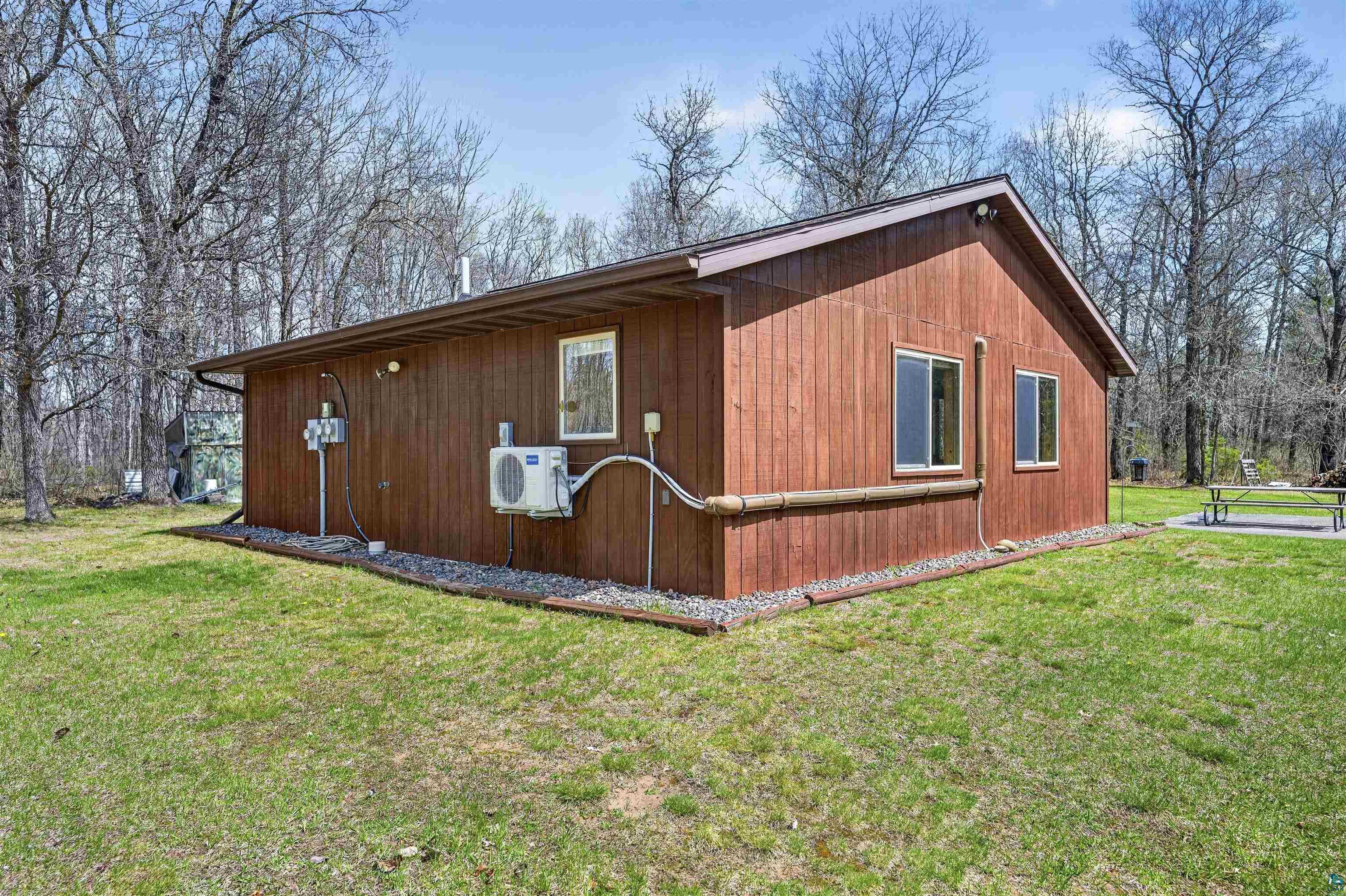 12235 East Crooked Lake Road Gordon, WI 54838 - Photo 34 of 48 Wood-sided exterior structure with a brown shingle roof, surrounded by mature trees