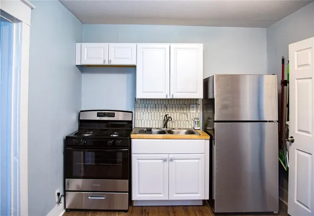 a kitchen with refrigerator and cabinets