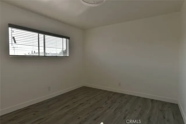 an empty room with wooden floor and a window