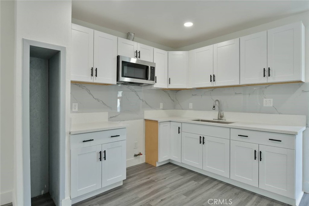 6221 Corona Avenue Bell Gardens, CA 90201 - Photo 39 of 65 a kitchen with white cabinets stainless steel appliances and sink