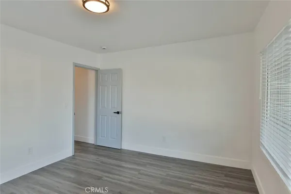 a view of a hallway with wooden floor and closet