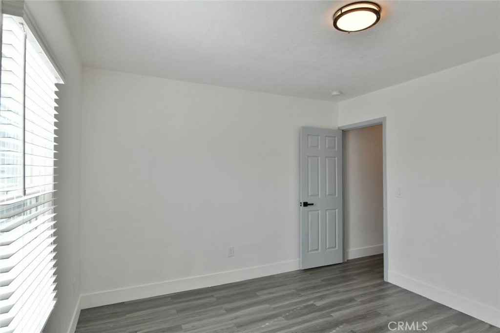 6221 Corona Avenue Bell Gardens, CA 90201 - Photo 48 of 65 an empty room with wooden floor and windows