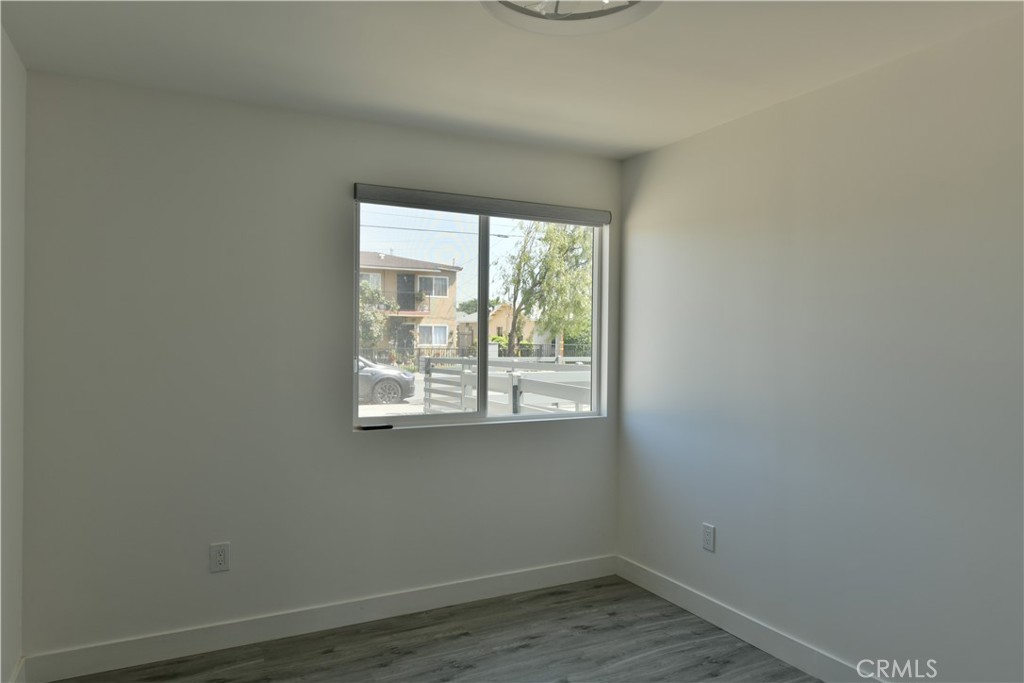 6221 Corona Avenue Bell Gardens, CA 90201 - Photo 59 of 65 an empty room with wooden floor and windows