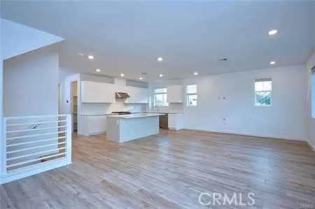 a view of kitchen with kitchen island wooden floors and center island