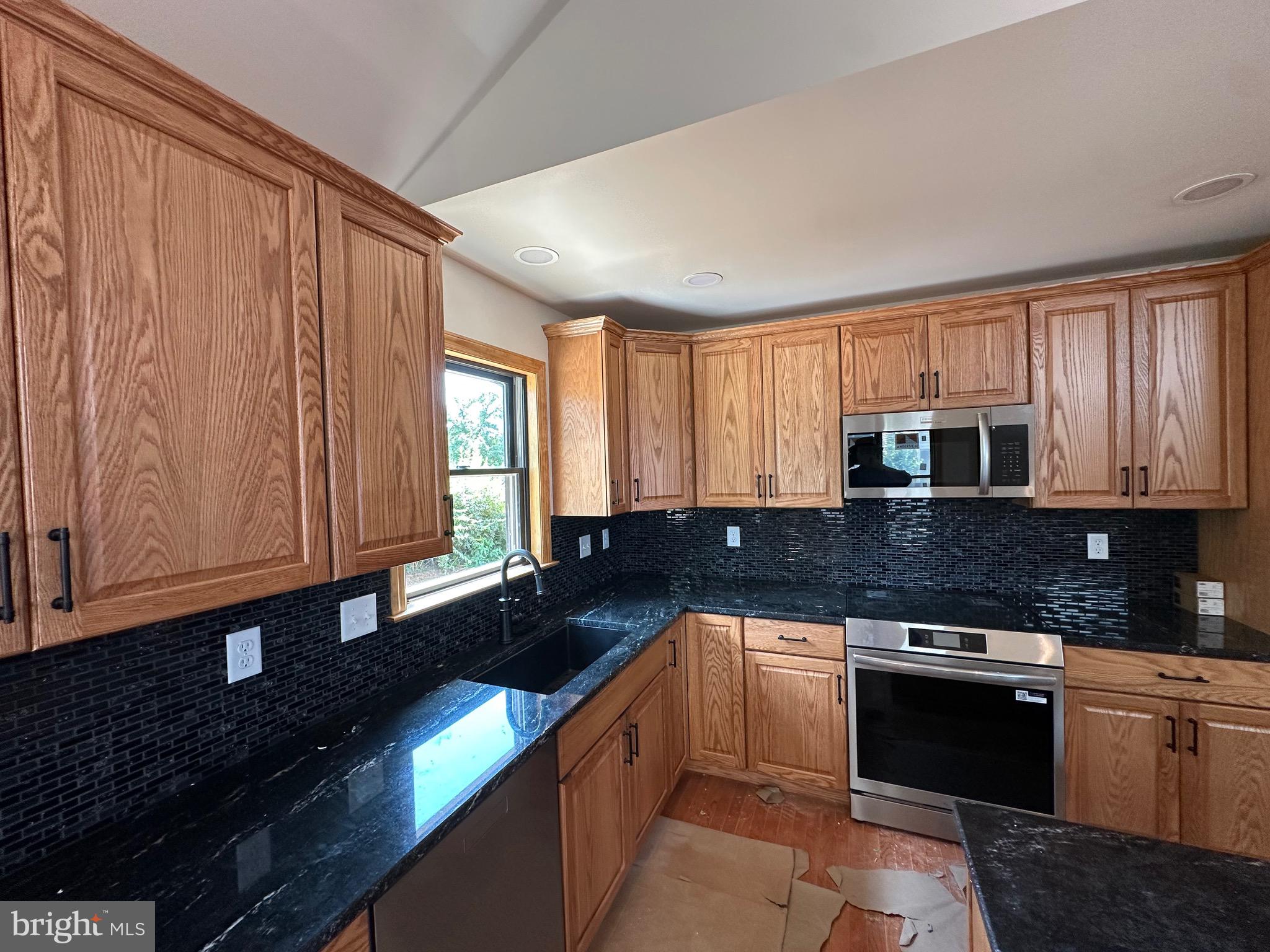 0 Braeburn Road Elizabethtown, PA 17022 - Photo 3 of 13 a kitchen with granite countertop a stove a sink dishwasher and cabinets with wooden floor