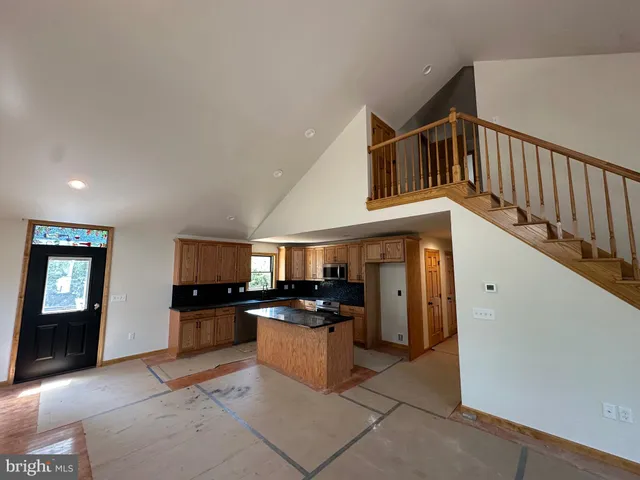 a kitchen with granite countertop a stove top oven and cabinets