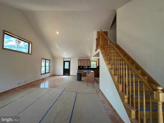 a view of a livingroom with wooden floor and stairs