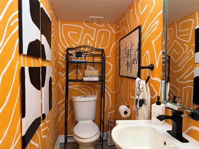 a kitchen with stainless steel appliances a table chairs in it and wooden floors