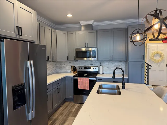 a kitchen with stainless steel appliances a sink stove and cabinets