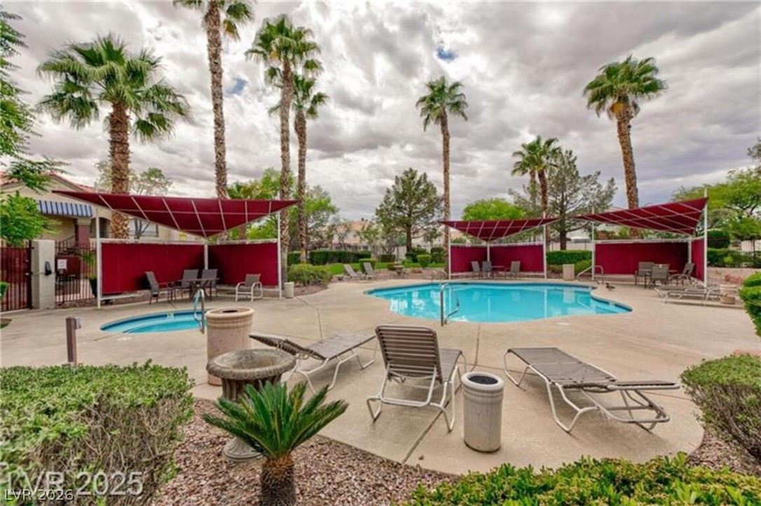 7885 West Flamingo Road, Unit 2171 Las Vegas, NV 89147 - Photo 2 of 22 Lush landscaping surrounds the refreshing pool and spa, inviting relaxation under shaded lounging areas.