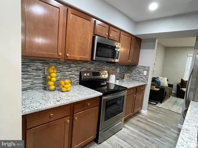 a kitchen with stainless steel appliances granite countertop a sink stove and microwave