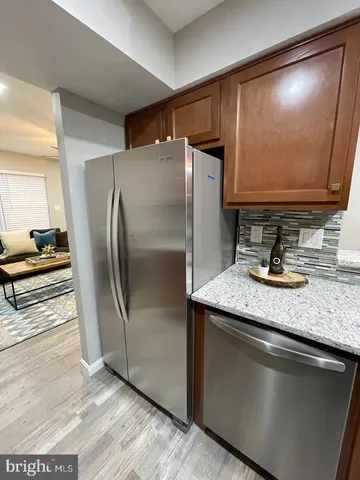 a kitchen with stainless steel appliances granite countertop a sink and a refrigerator