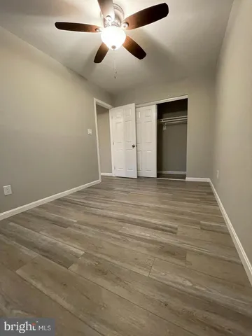 an empty room with fan and windows