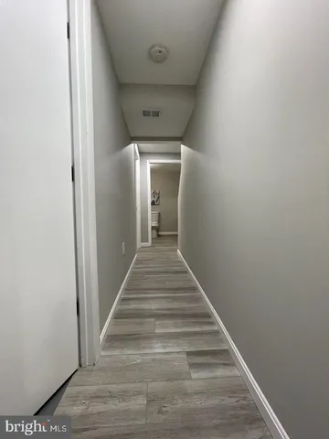 a view of a hallway with wooden floor and entryway