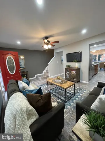 a living room with furniture a rug and a flat screen tv