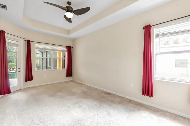 an empty room with windows and ceiling fan
