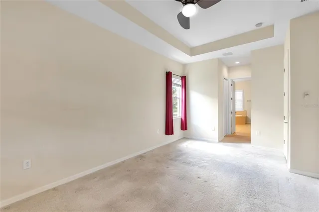 en empty room with ceiling fan and window
