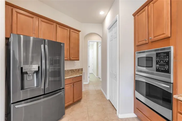 a kitchen with stainless steel appliances granite countertop a refrigerator and a stove top oven