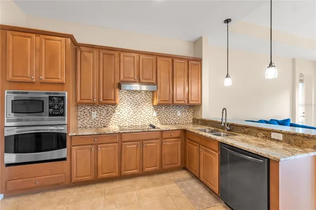 a kitchen with stainless steel appliances granite countertop a sink a stove and a microwave