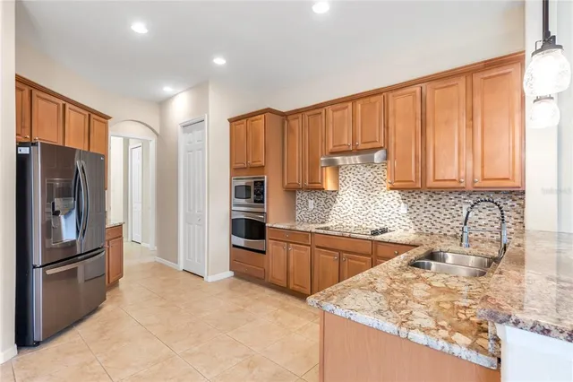 a kitchen with stainless steel appliances granite countertop a refrigerator and a sink