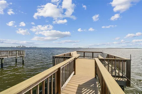 a view of a dining room and livingroom with furniture wooden floor a chandelier