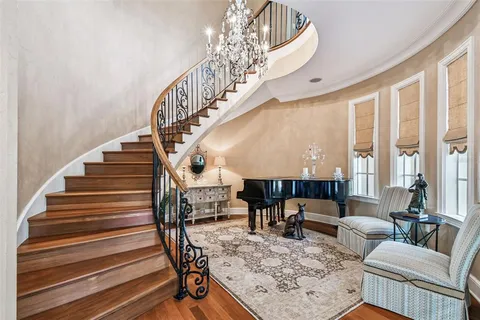 a dining room with wooden floor a chandelier a wooden table and chairs