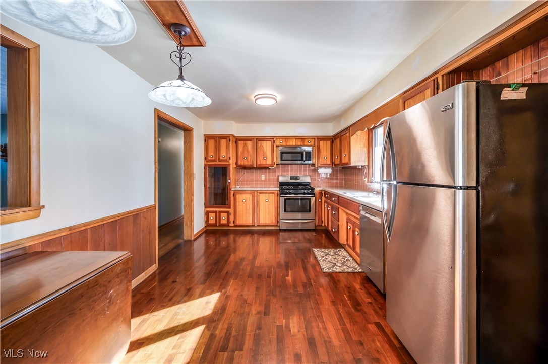 3210 Oser Road Norton, OH 44203 - Photo 21 of 47 Kitchen with sink, tasteful backsplash, hanging light fixtures, dark hardwood / wood-style flooring, and stainless steel appliances
