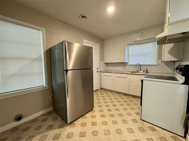 a kitchen with stainless steel appliances granite countertop a refrigerator sink and microwave