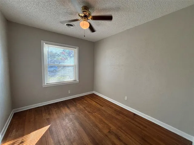 a view of room with hardwood floor and ceiling fan