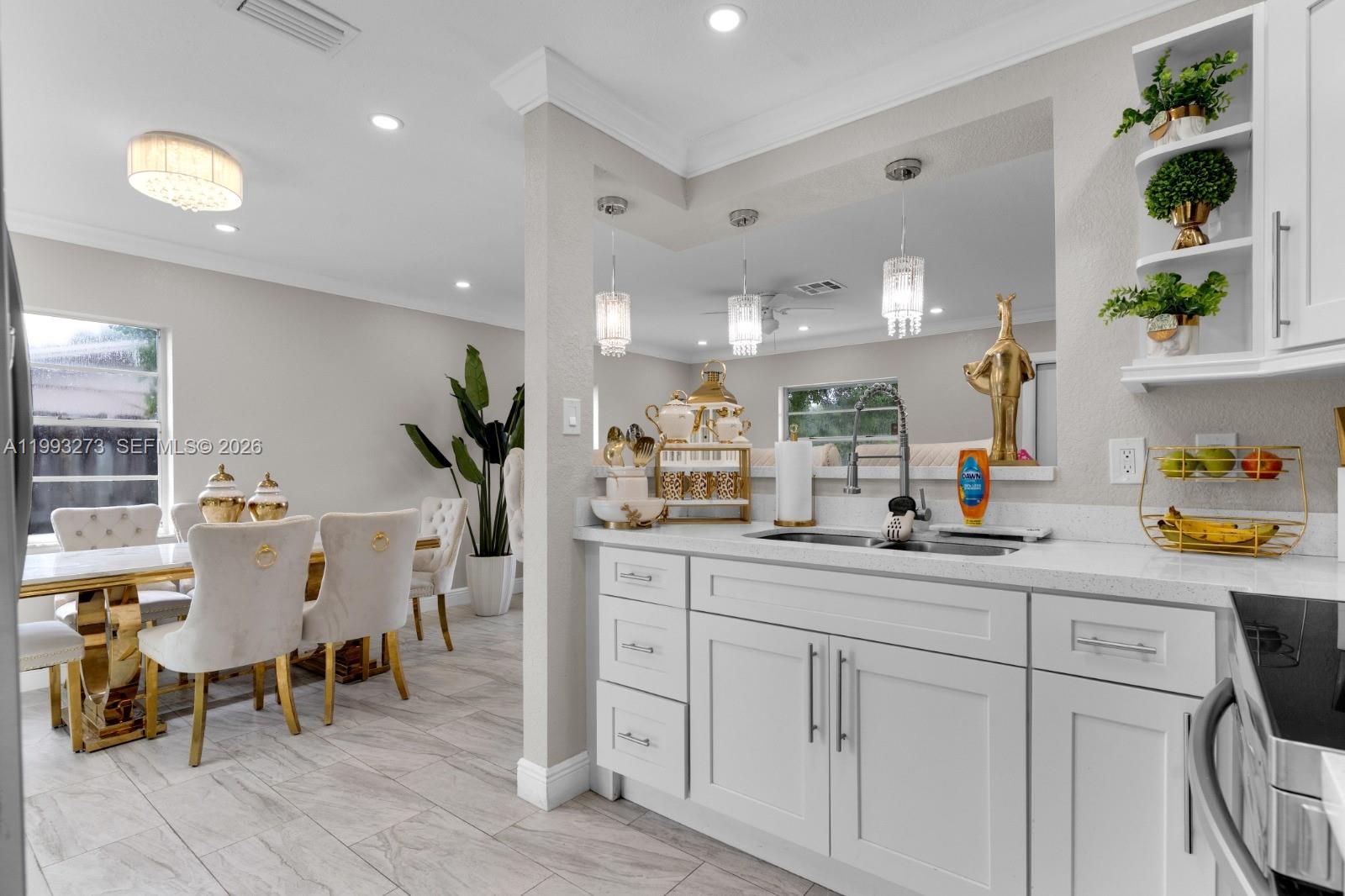 30534 Southwest 155th Court Homestead, FL 33033 - Photo 13 of 33 a kitchen with white cabinets a table and chairs