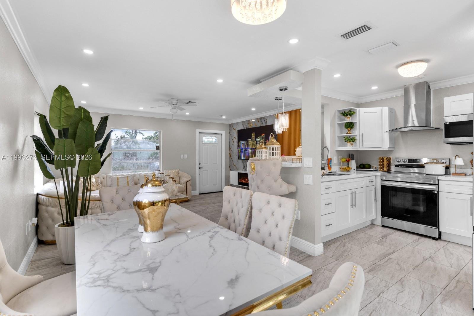 30534 Southwest 155th Court Homestead, FL 33033 - Photo 8 of 33 a large white kitchen with stainless steel appliances granite countertop a stove a sink a dining table and chairs with the wooden floor
