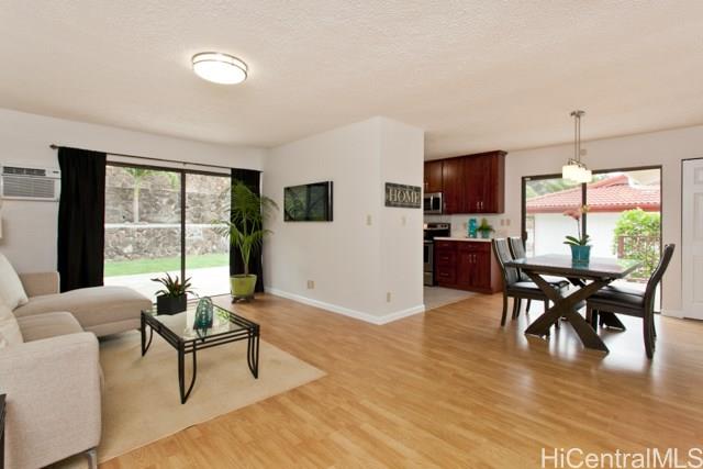 a living room with furniture wooden floor and a floor to ceiling window