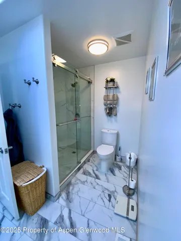 a bathroom with a granite countertop toilet a sink and a shower