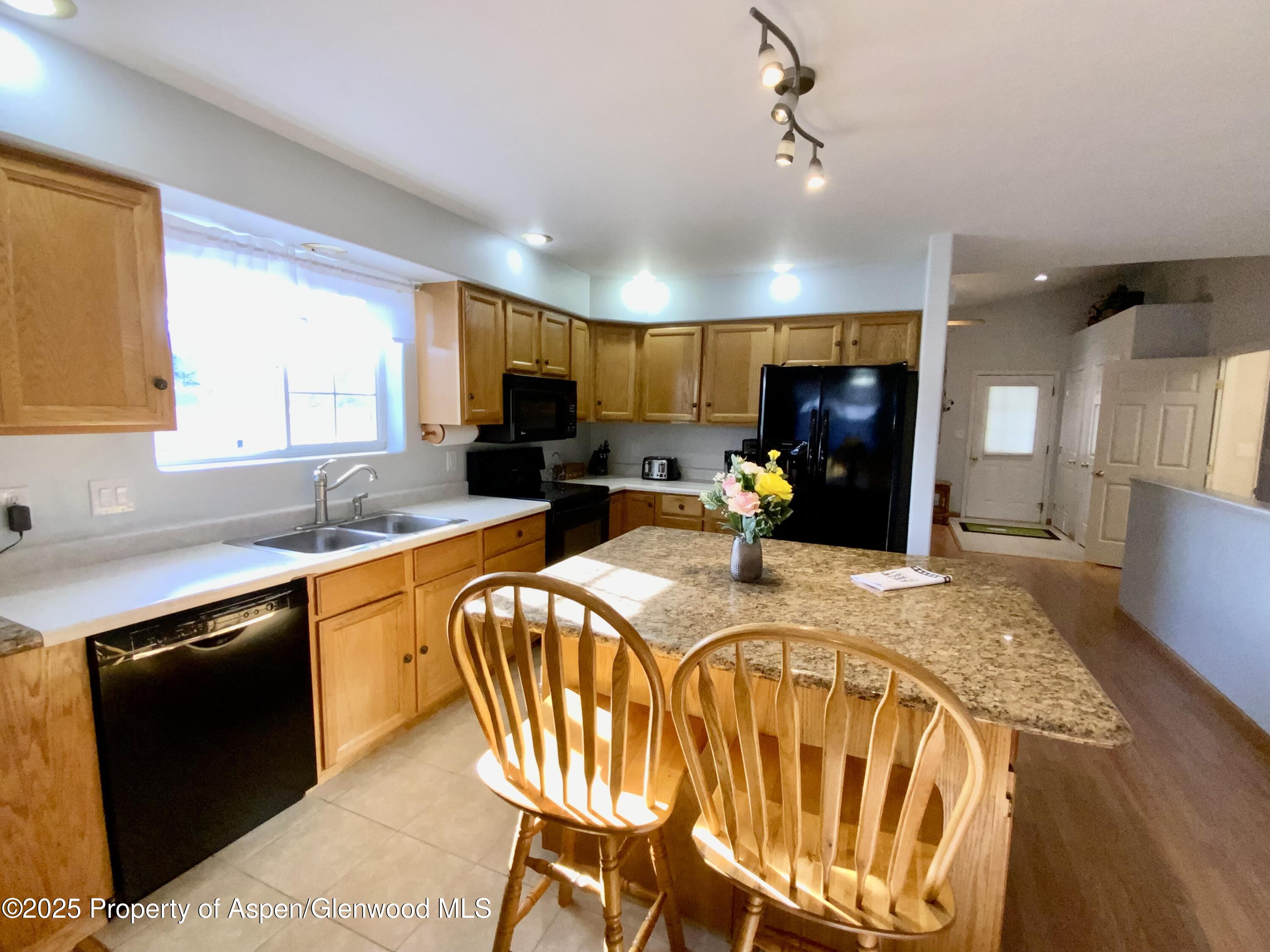 660 Aspen Avenue Rifle, CO 81650 - Photo 6 of 30 a kitchen with sink a refrigerator and chairs