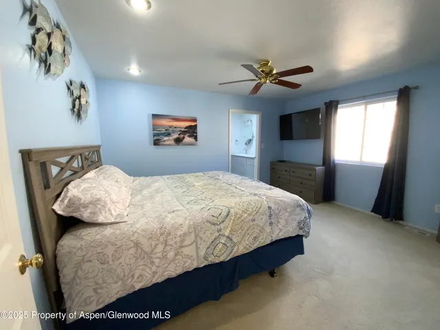 a bedroom with a bed and a painting on the wall