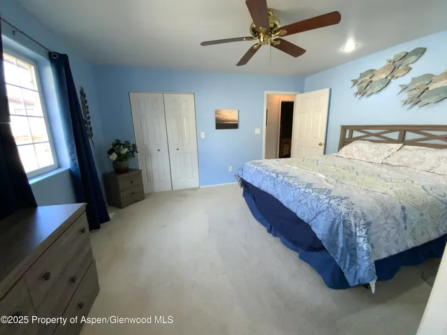 a spacious bedroom with a bed and a chandelier