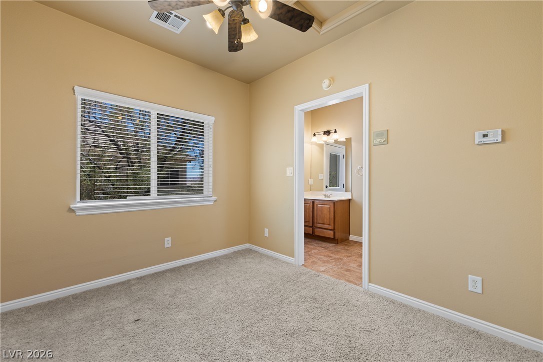575 Gann Avenue Logandale, NV 89021 - Photo 52 of 75 Casita: A comfortable bedroom with a view of mature trees, offering direct access to a private bathroom.
