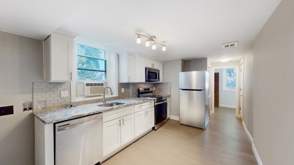 149 Winthrop Road, Unit 2 Brookline, MA 02445 - Photo 2 of 11 a kitchen with stainless steel appliances granite countertop a sink stove and refrigerator