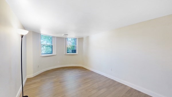 149 Winthrop Road, Unit 2 Brookline, MA 02445 - Photo 3 of 11 a view of an empty room with window and wooden floor