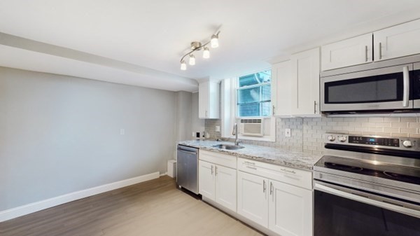 149 Winthrop Road, Unit 2 Brookline, MA 02445 - Photo 4 of 11 a kitchen with stainless steel appliances a stove microwave and cabinets