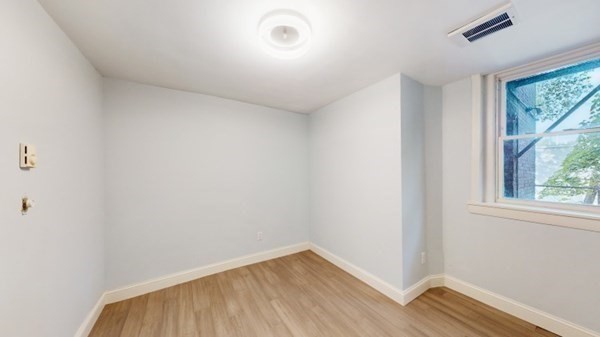 149 Winthrop Road, Unit 2 Brookline, MA 02445 - Photo 5 of 11 an empty room with wooden floor and windows