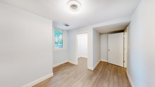 149 Winthrop Road, Unit 2 Brookline, MA 02445 - Photo 6 of 11 an empty room with wooden floor and windows