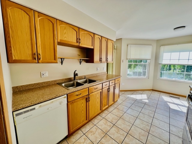 716 Sutton Circle Wheeling, IL 60090 - Photo 16 of 38 a kitchen with stainless steel appliances a sink cabinets and a window