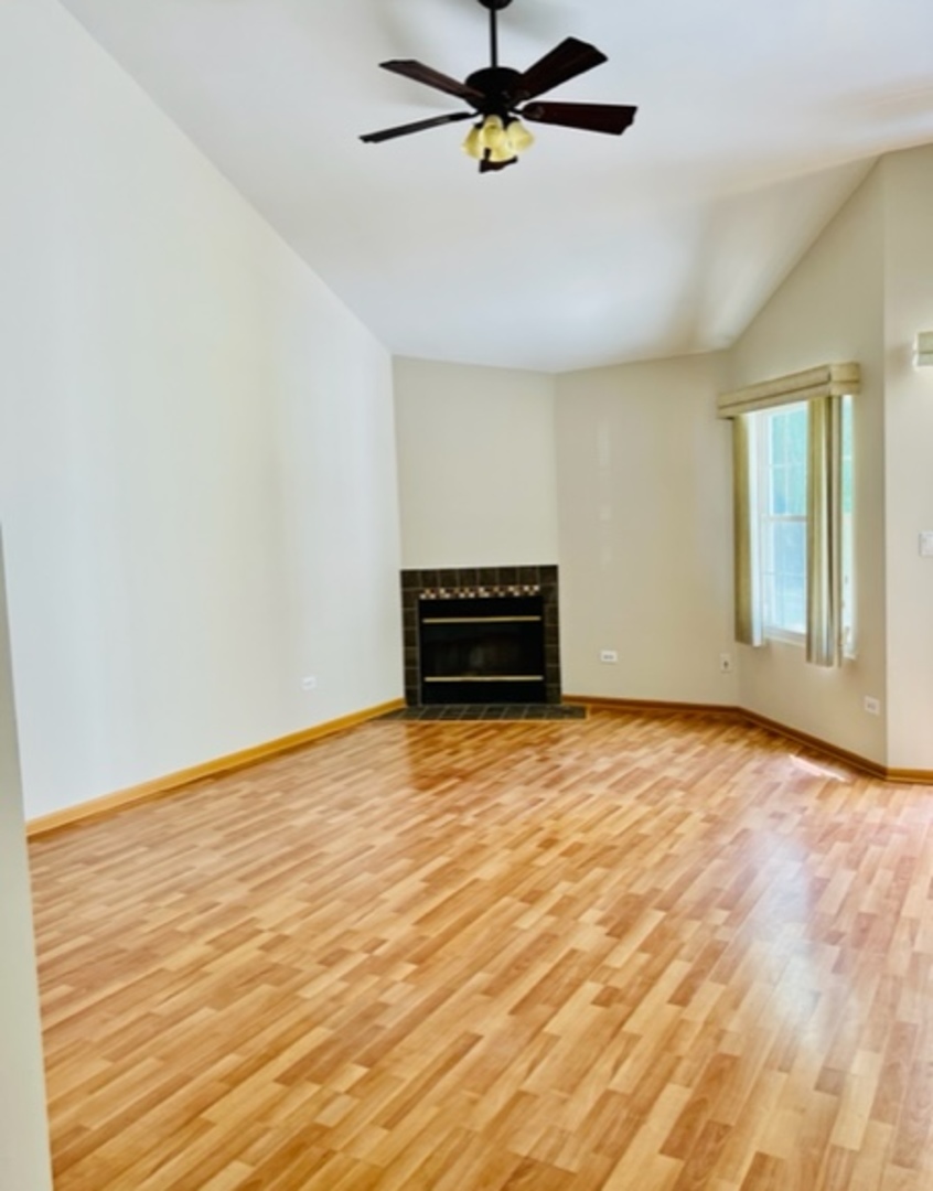 716 Sutton Circle Wheeling, IL 60090 - Photo 8 of 38 an empty room with a ceiling fan and window