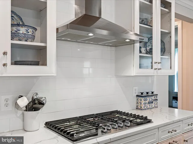 a kitchen with stainless steel appliances granite countertop a refrigerator sink and white cabinets