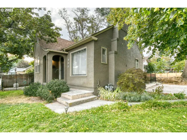 a backyard of a house with outdoor seating and plants